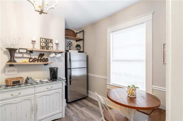 kitchen featuring open shelves, freestanding refrigerator, and light wood-style flooring