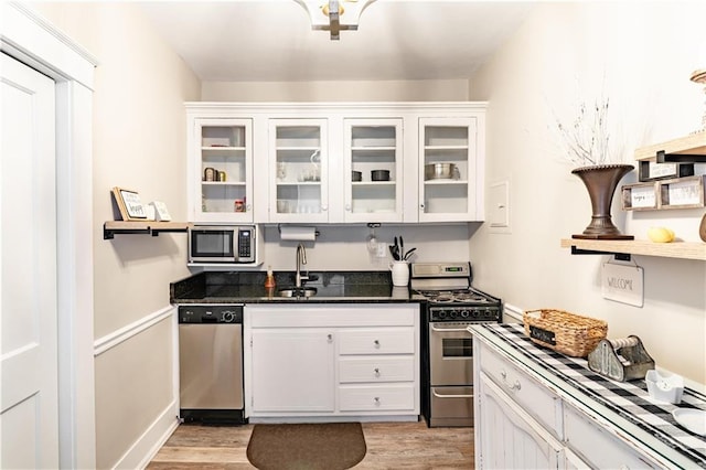 kitchen featuring appliances with stainless steel finishes, light wood-type flooring, and white cabinetry