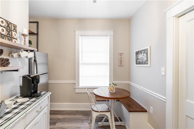 dining space with wood finished floors, baseboards, and breakfast area