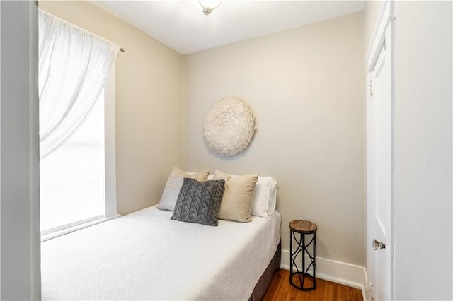 bedroom with wood finished floors and baseboards