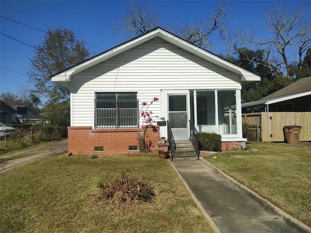 bungalow-style house featuring a sunroom and a front yard