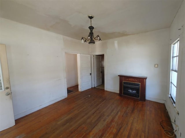 unfurnished living room with dark hardwood / wood-style flooring and a chandelier