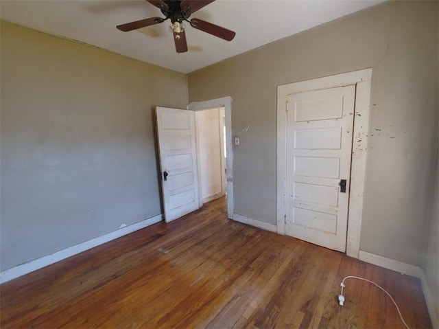 unfurnished bedroom featuring ceiling fan and dark hardwood / wood-style flooring