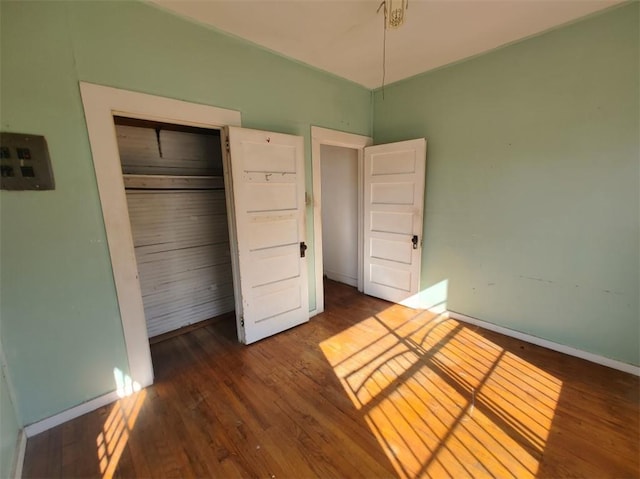 unfurnished bedroom featuring dark hardwood / wood-style flooring and a closet