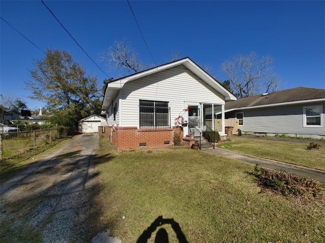 view of front of house with a garage, an outdoor structure, and a front lawn