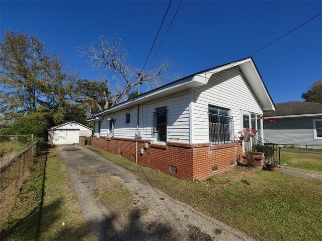 view of side of home featuring a garage, a yard, and an outbuilding