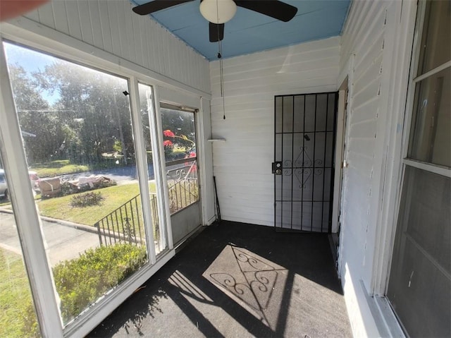 unfurnished sunroom with ceiling fan