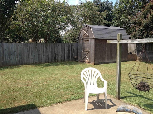 view of yard with an outdoor structure, a storage unit, a fenced backyard, and a patio