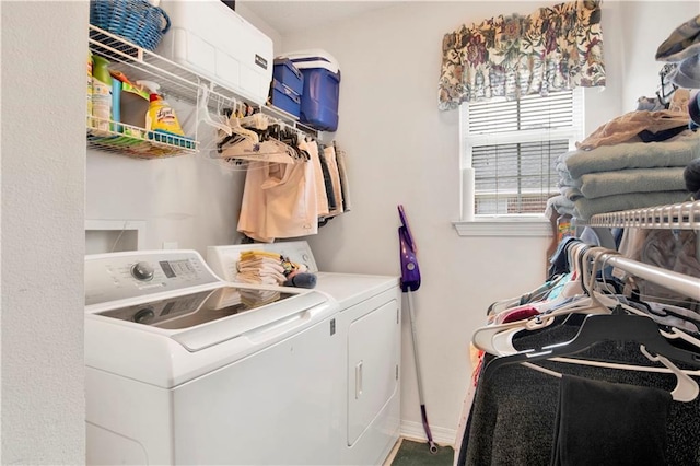 clothes washing area with baseboards, washing machine and dryer, and laundry area