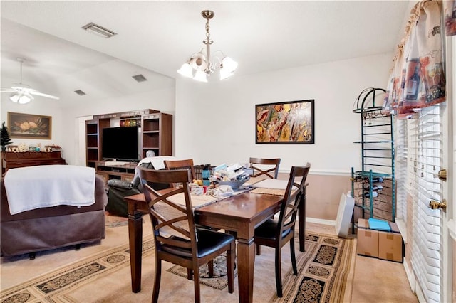 dining room featuring light carpet, visible vents, ceiling fan with notable chandelier, and baseboards