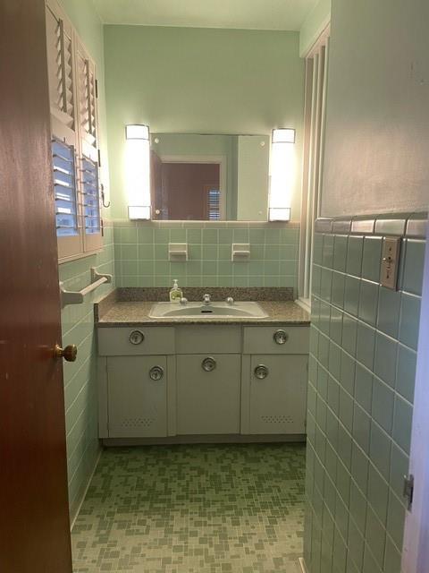 bathroom with vanity and tile walls