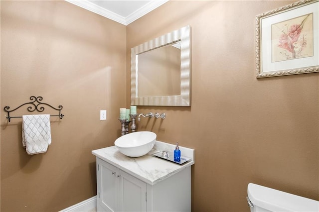 bathroom featuring vanity, toilet, and crown molding