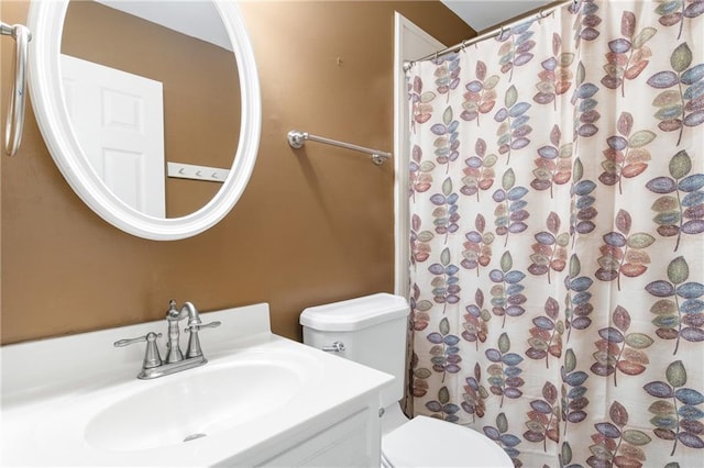 bathroom with a shower with shower curtain, vanity, and toilet