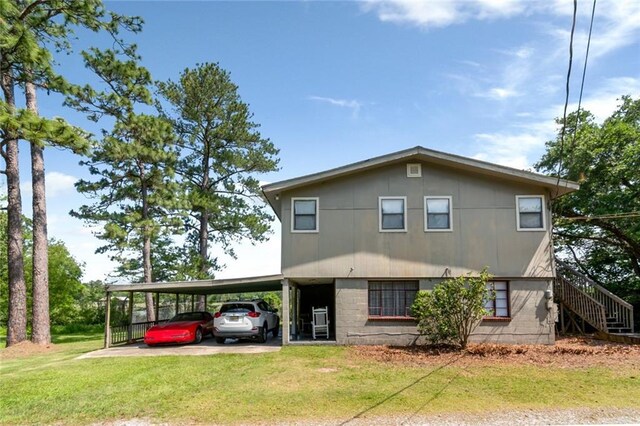 2100 River Forest Rd, Mobile, AL 36605 - view of front facade featuring a front lawn, stairs, a carport, and driveway