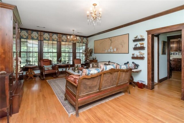 2100 River Forest Rd, Mobile, AL 36605 - living room with a chandelier, crown molding, wood finished floors, and baseboards