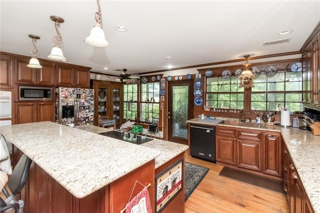2100 River Forest Rd, Mobile, AL 36605 - kitchen featuring black appliances, crown molding, light stone counters, a sink, and a center island