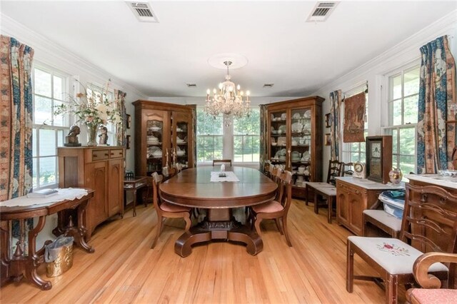 2100 River Forest Rd, Mobile, AL 36605 - dining space featuring a chandelier, healthy amount of natural light, crown molding, and light wood-style floors