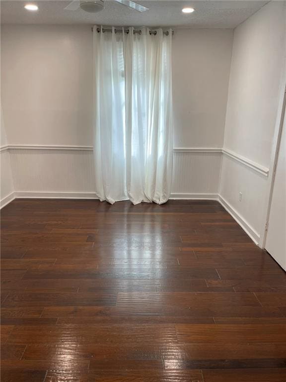 spare room with ceiling fan and dark hardwood / wood-style flooring