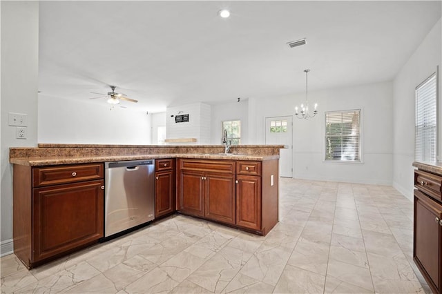 kitchen featuring hanging light fixtures, light stone countertops, stainless steel dishwasher, ceiling fan with notable chandelier, and sink