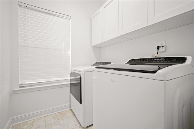 washroom featuring washing machine and dryer and cabinets