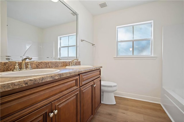 full bathroom with vanity, toilet, wood-type flooring, and shower / washtub combination