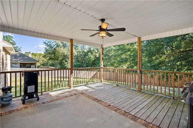 wooden terrace featuring ceiling fan and a lawn