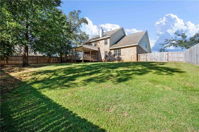 back of house featuring a wooden deck and a yard