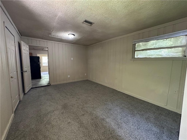 1820 N Barkley Dr, Mobile, AL 36606 - spare room featuring a textured ceiling, carpet flooring, and wooden walls