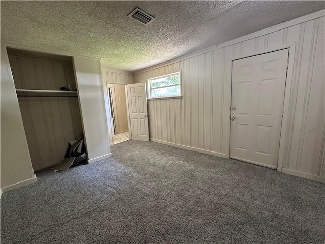 1820 N Barkley Dr, Mobile, AL 36606 - unfurnished bedroom featuring a closet, a textured ceiling, carpet, and wooden walls