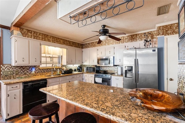 kitchen with light stone counters, a textured ceiling, black appliances, crown molding, and sink