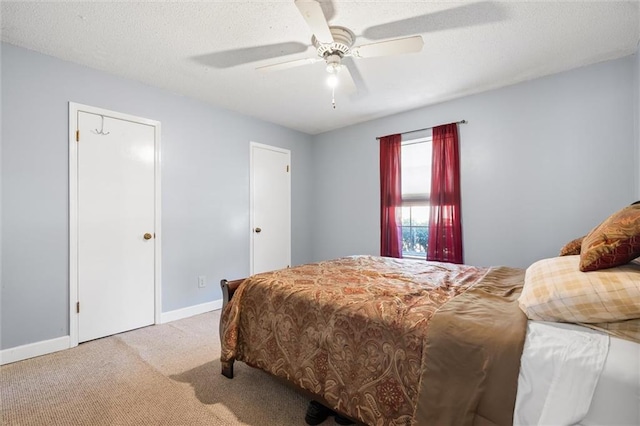 carpeted bedroom with a textured ceiling and ceiling fan