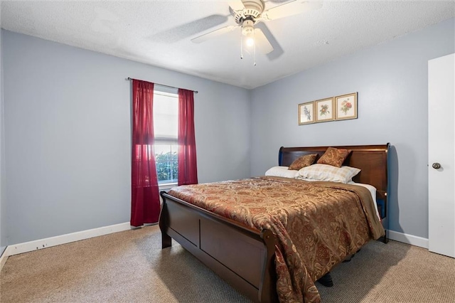 bedroom with ceiling fan, light carpet, and a textured ceiling