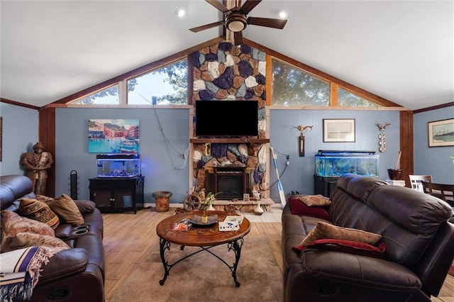 living room with ceiling fan, a stone fireplace, a wealth of natural light, and light wood-type flooring