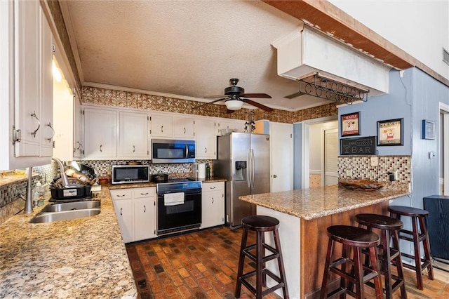 kitchen with sink, stainless steel appliances, white cabinets, crown molding, and a breakfast bar