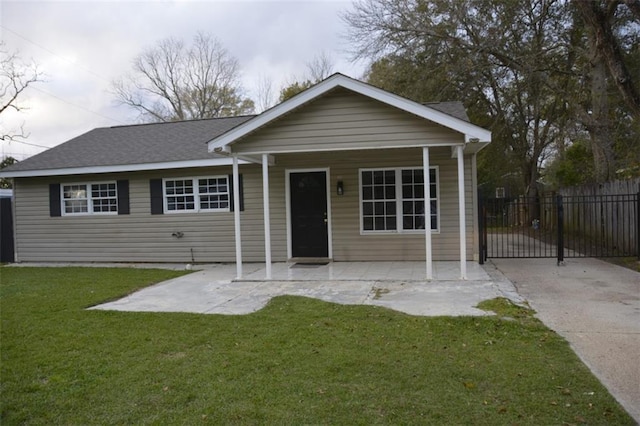 view of front of home featuring a gate, a patio, fence, concrete driveway, and a front yard