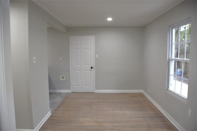 spare room featuring recessed lighting, baseboards, wood finished floors, and crown molding
