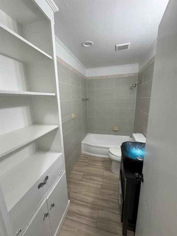 full bathroom featuring visible vents, toilet, a textured ceiling, vanity, and wood tiled floor