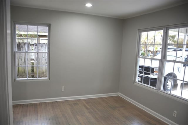 spare room with recessed lighting, a healthy amount of sunlight, baseboards, and dark wood-style flooring