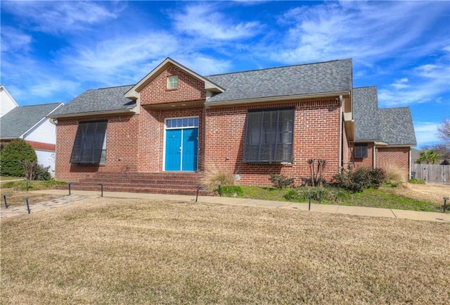 single story home with brick siding, roof with shingles, and a front lawn