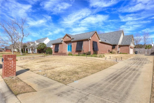 ranch-style house with brick siding, driveway, a garage, and fence