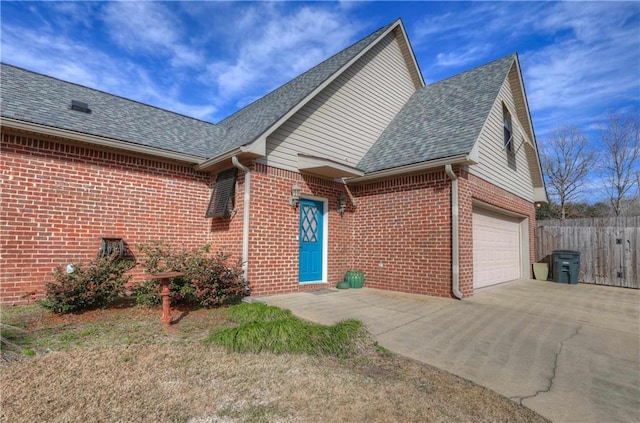 view of front of property with brick siding, a shingled roof, fence, concrete driveway, and a garage