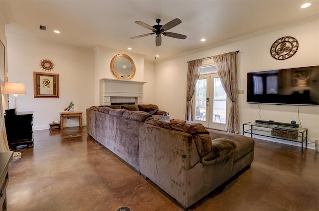 living room featuring a tiled fireplace, crown molding, and ceiling fan