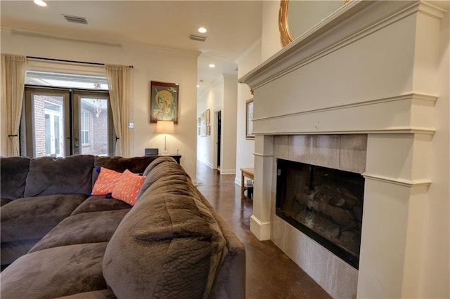 living room featuring a tiled fireplace and french doors