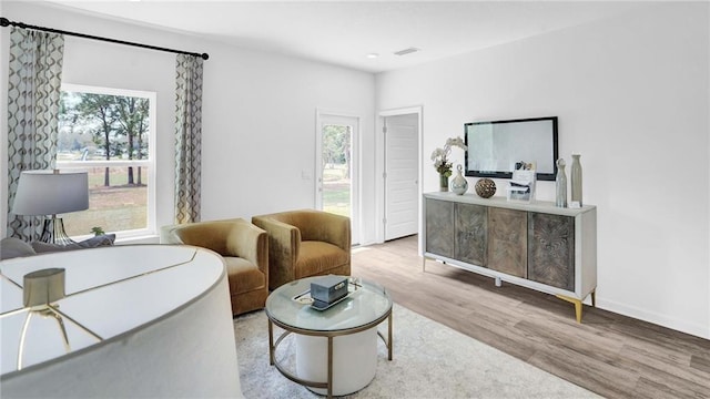 living area featuring healthy amount of natural light, wood finished floors, and baseboards