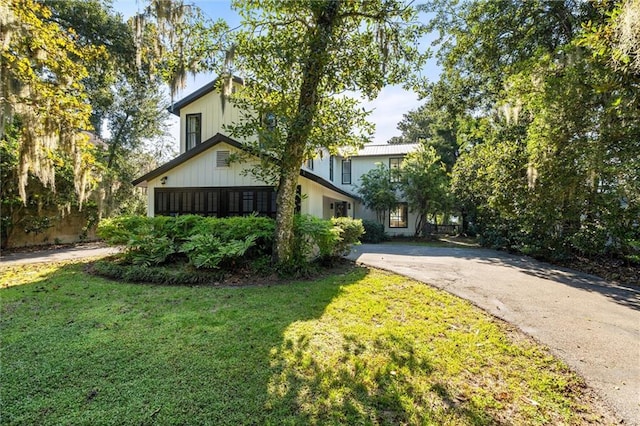 view of property hidden behind natural elements with a front lawn