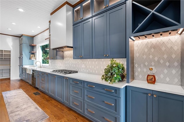 kitchen with blue cabinets, crown molding, and dark hardwood / wood-style flooring