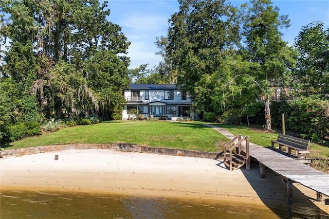 view of dock featuring a lawn and a water view