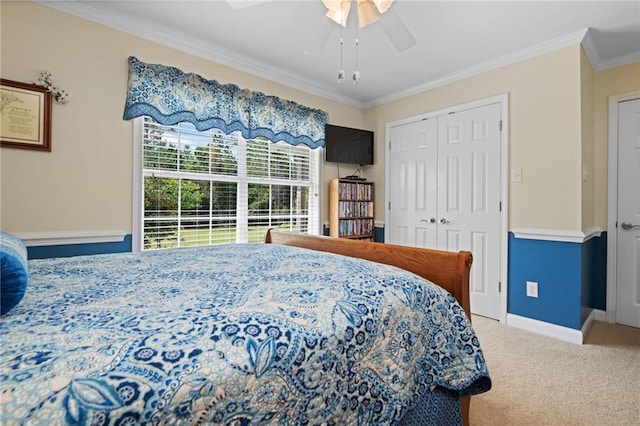 carpeted bedroom featuring crown molding, ceiling fan, and a closet