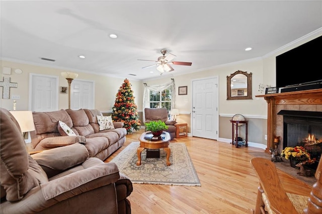 living room featuring crown molding, ceiling fan, and light hardwood / wood-style floors