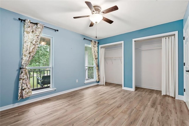 unfurnished bedroom with ceiling fan, light wood-type flooring, and multiple closets